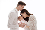Eltern mit einem Baby küssen sich